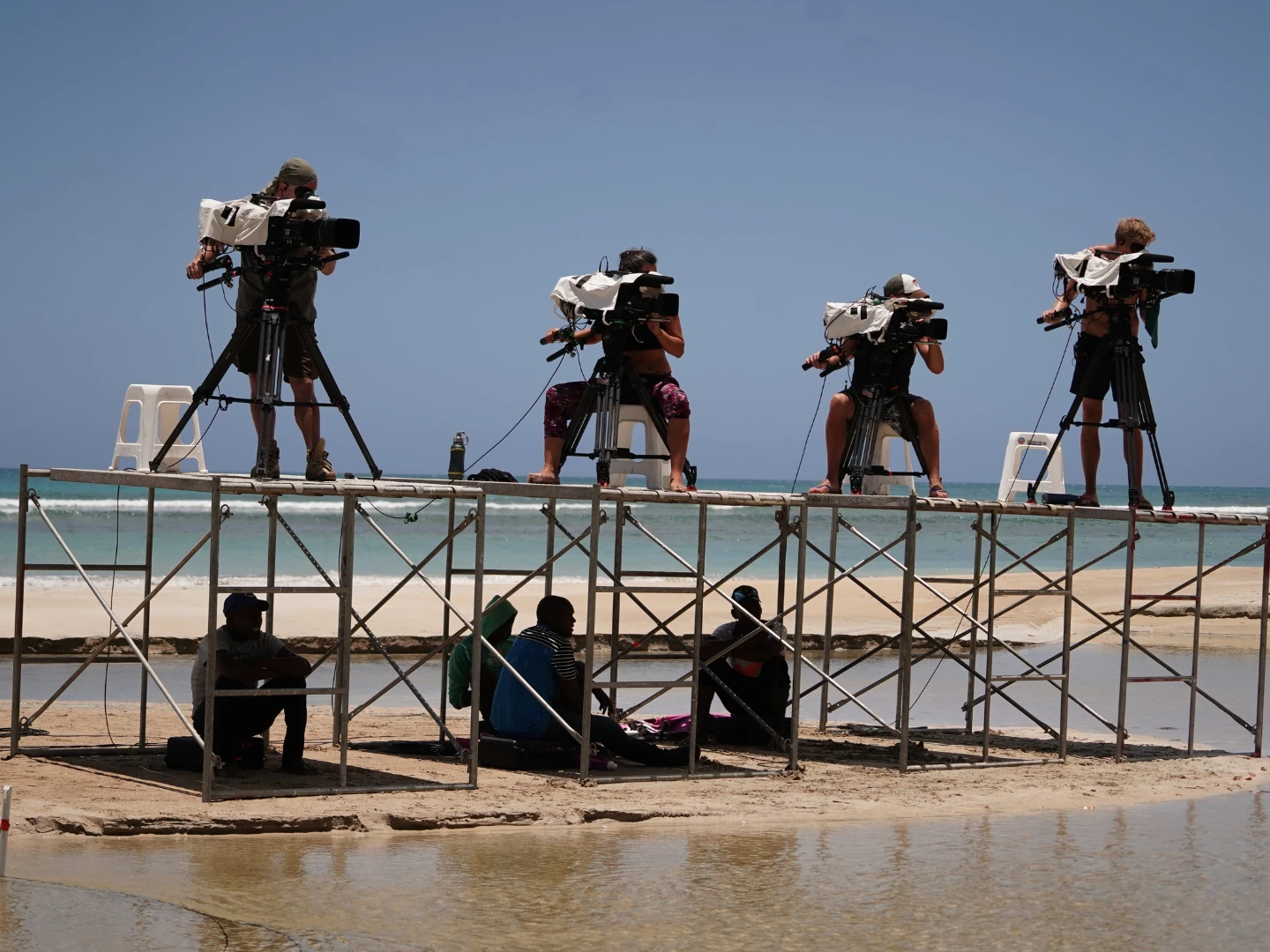 Team filming on a beach